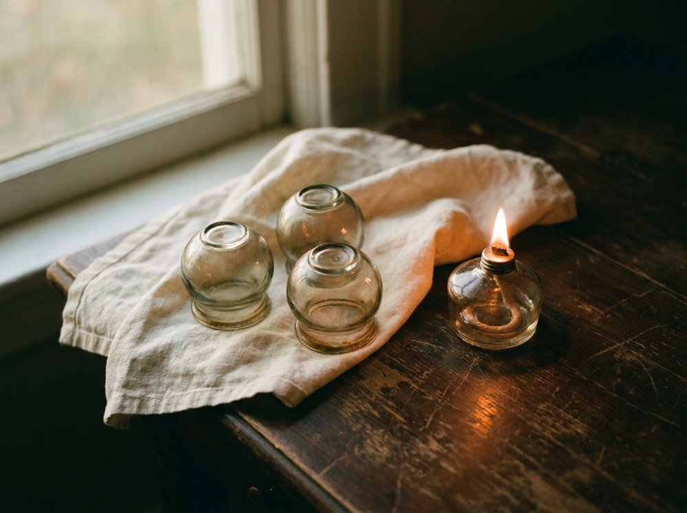 Glass ventosa cups arranged on a clean linen cloth